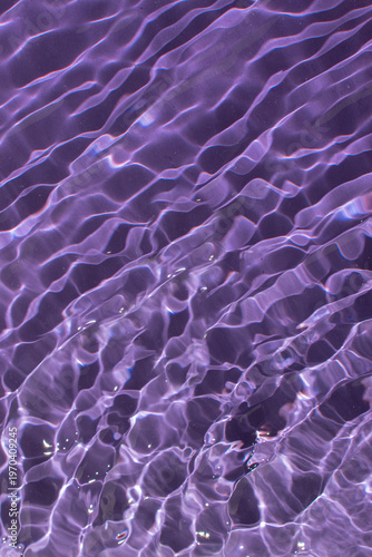 Obraz na plátně Water with a shining rippled texture on a dark purple background