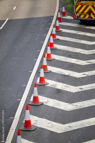 Bild auf Leinwand Road work - cones layed out along the bull nose of  chevrons of a motorway junction as the road is closed for highway maintenance