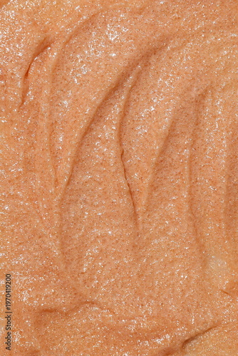 Close-up macro texture of shimmering beige cosmetic scrub with fine particles
