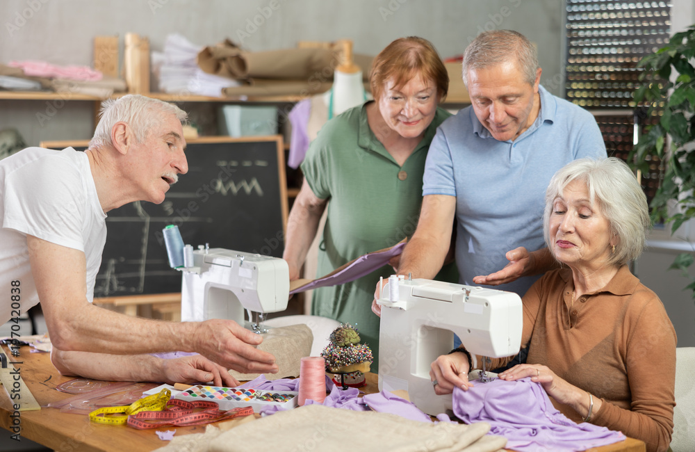 Obraz premium During educational lesson on cutting and sewing, elderly students listen to senior female teacher, watch demonstration, and gain skills in hand-made clothing..