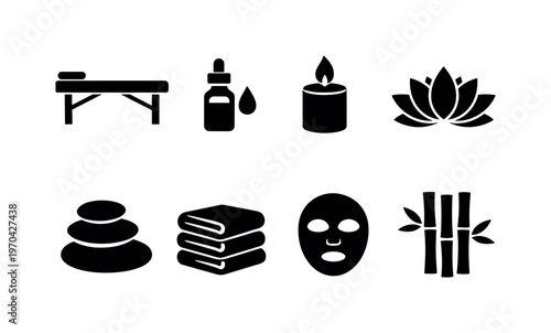 Spa wellness: massage table, essential oil bottle, candle, lotus flower, hot stones, towel stack, facial mask, bamboo sticks