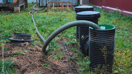 Sewage pumping service clearing a septic tank system in a rural backyard