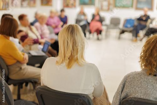 Group of women sitting in a circle during a meeting in a community center focused on discussion and sharing ideas