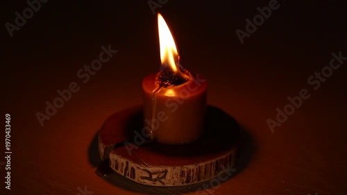 Closeup candle beautiful burning on dark shadow red warm background, candle fire flame light with empty copy space. Magic ritual with romantic candle wax fire