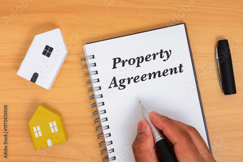 Property Agreement Concept with house model for Real Estate Contracts and Ownership Documentation