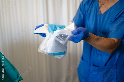 Fotografija Medical professional opening sterile surgical equipment package