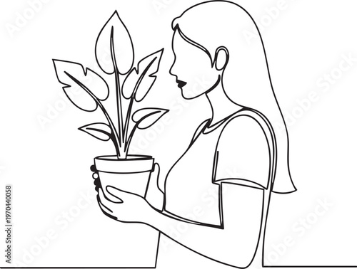 A woman holding a potted plant with large leaves in her hands carefully