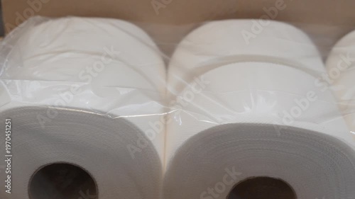 Pack of toilet paper rolls arranged horizontally in storage box. Shot emphasizes bulk purchase and practical household supply concept.
