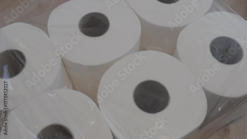Multiple toilet paper rolls packed together under transparent wrap. Shot conveys storage, supply and everyday necessity concept.