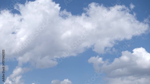 Time lapse of white clouds moving and drifting across a blue sky, weather and nature concept