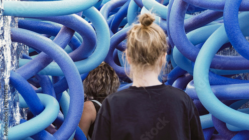 Fotografi People observing a captivating modern art installation with blue interconnected