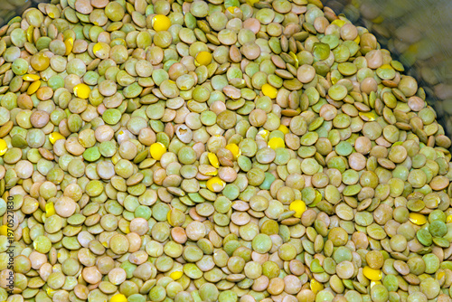 Raw organic green lentils pattern inside metal pot