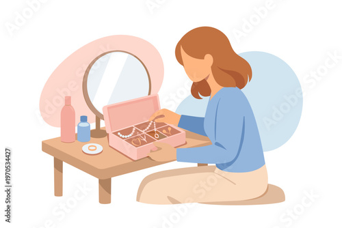 Young woman choosing jewelry from a box at her dressing table