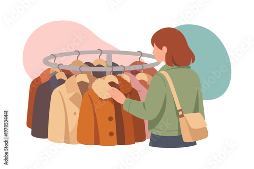 Woman browsing coats on a circular clothing rack in a store
