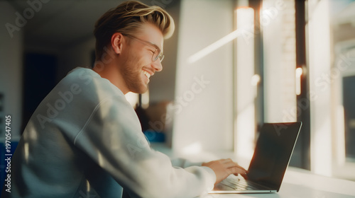 Digital Embrace: A person sits by a window, the gentle light illuminating their face as they engage with a laptop, exuding contentment and focus in the digital age.