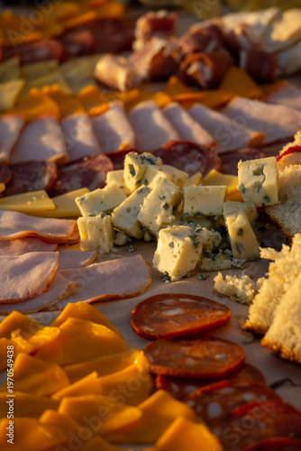 Lavish charcuterie board and grazing table with cheeses, fruits, and cold cuts.
