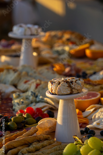 Lavish charcuterie board and grazing table with cheeses, fruits, and cold cuts.