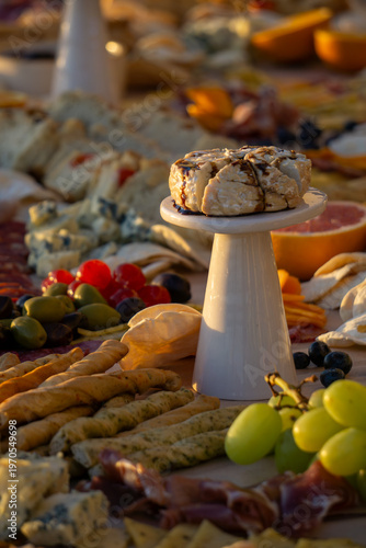 Lavish charcuterie board and grazing table with cheeses, fruits, and cold cuts.