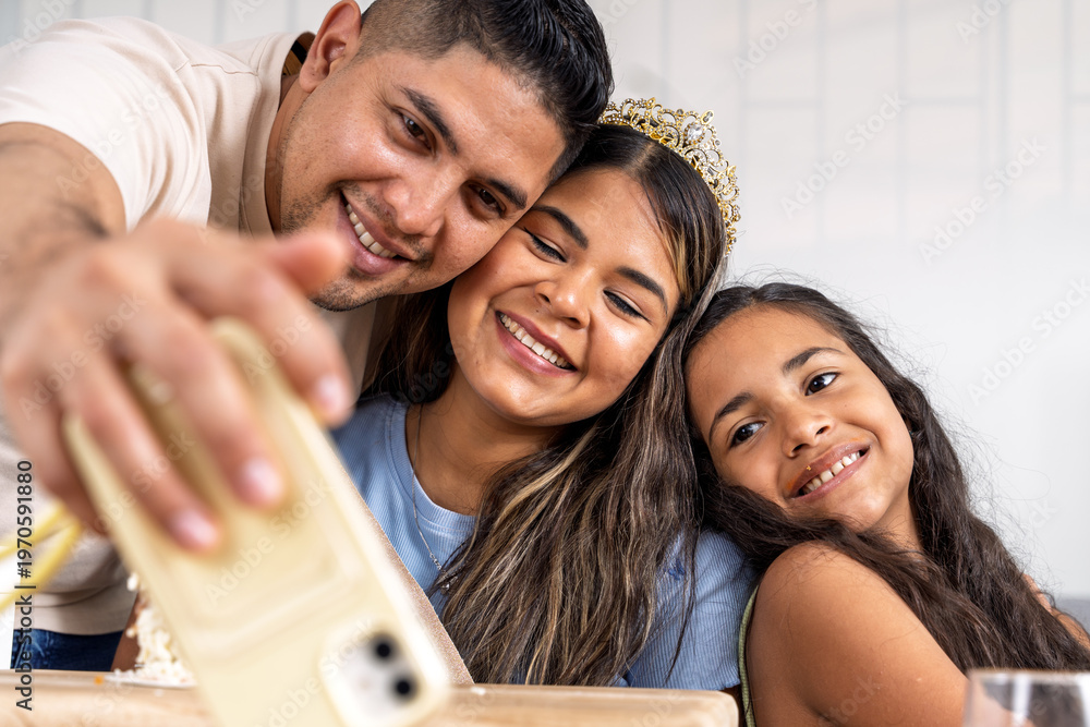 Obraz premium Hispanic family celebrating birthday taking a selfie indoors