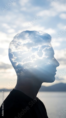 Double exposure of a mans profile with a cloudy sky symbolizing thought and consciousness.