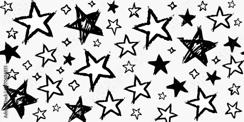 A scattered arrangement of hand drawn black and white stars on a plain background