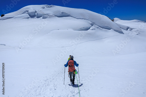 Mountaineers in rope team with crampons descending, mountain summit Parrotspitze on Monte Rosa massif and glacier panorama in Pennine Alps, Switzerland