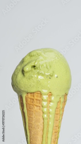 4K Vertical video Time-lapse Melting matcha green tea ice cream in waffle cone with dripping creamy texture Close-up dessert showing summer heat and premium flavor.
