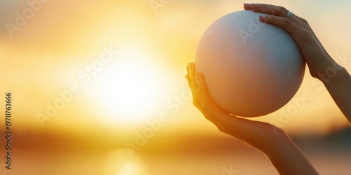 A person holds a basketball at sunset, with warm light highlighting the ball and hands against a blurred background.
