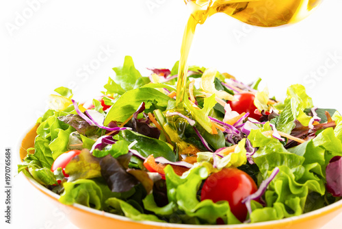 野菜サラダにオリーブオイルを掛ける