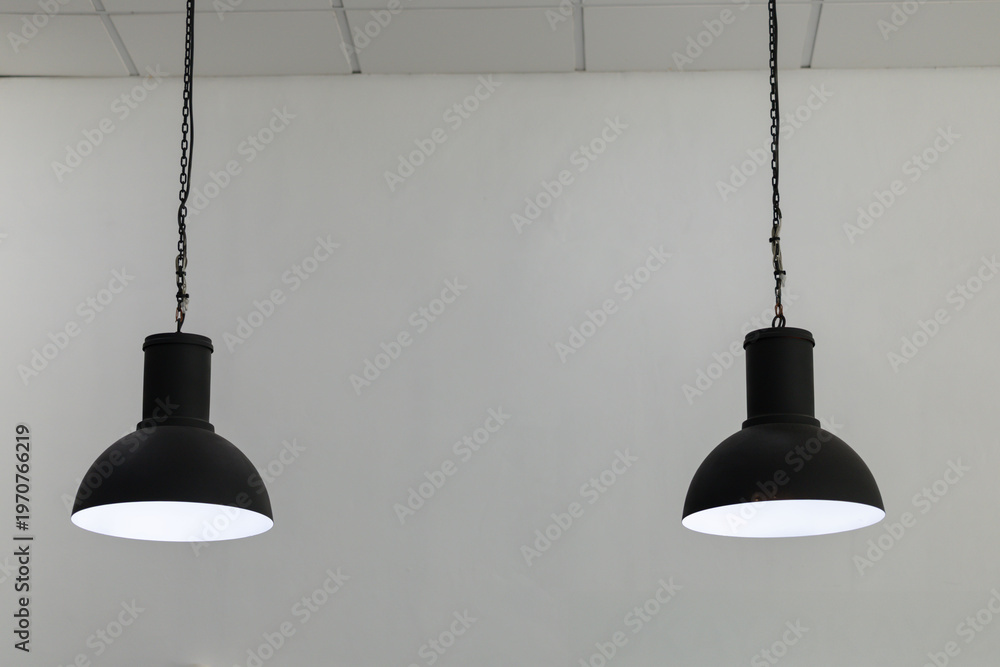 Obraz premium Black industrial-style hanging lights illuminate minimalist white interior
