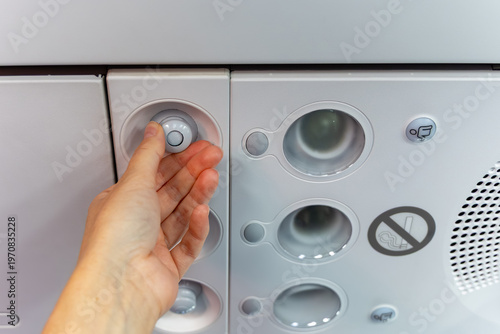 Tableau sur toile Airplane air conditioning control panel with a hand adjusting the temperature di