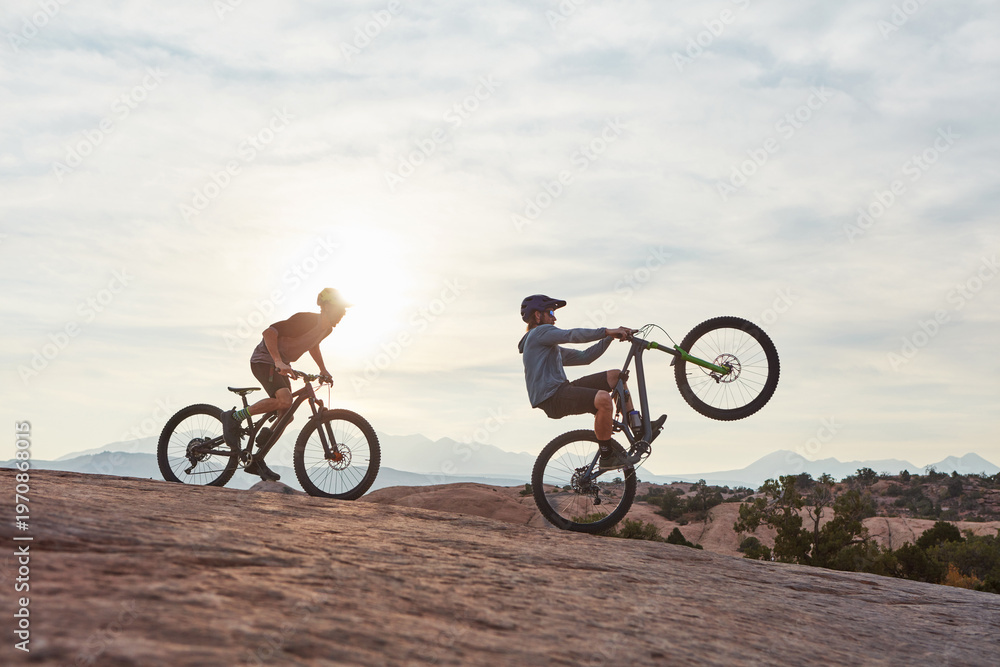 Fototapeta premium Mountain bike, men and adventure for training, travel and extreme sports with hobby. Sunshine, healthy people and friends with practice, balance or journey to explore, adrenaline or power performance