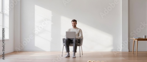 Man enjoys quiet time while working on his laptop in a sunlit modern room