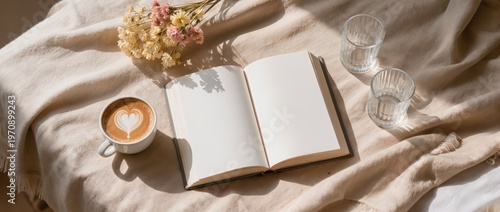 Cozy morning scene with coffee, an open book, and fresh flowers on a soft blanket