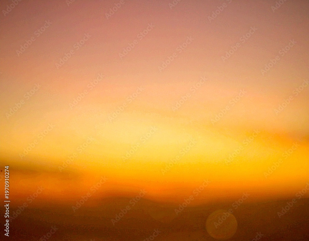 Fototapeta premium 海辺の夕陽のオレンジ色の空のぼやけた背景