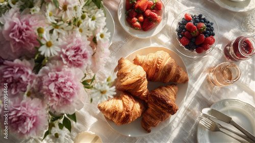 Mother's Day brunch table top view with golden croissants, fresh berries, jam. Pink carnations and daisies with dew. Cinematic soft morning light, warm atmosphere. Copy space on right for text/logo.