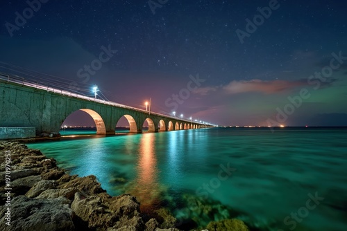 Coastal highway lights streak across bridge under stars