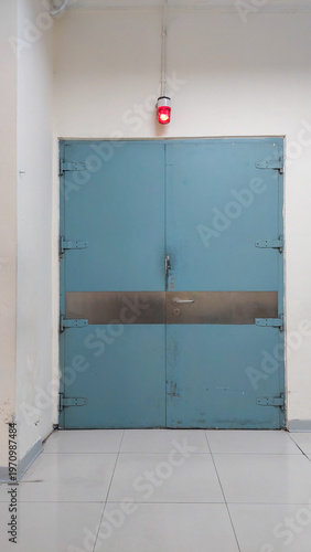 Industrial Metal Emergency Double Door with Red Warning Light for Safety Concept, Security Background, Corporate Presentation, Website, and Industrial Branding