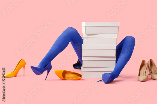 Fotografija Female legs in tights with stylish high heels and cardboard boxes on pink backgr