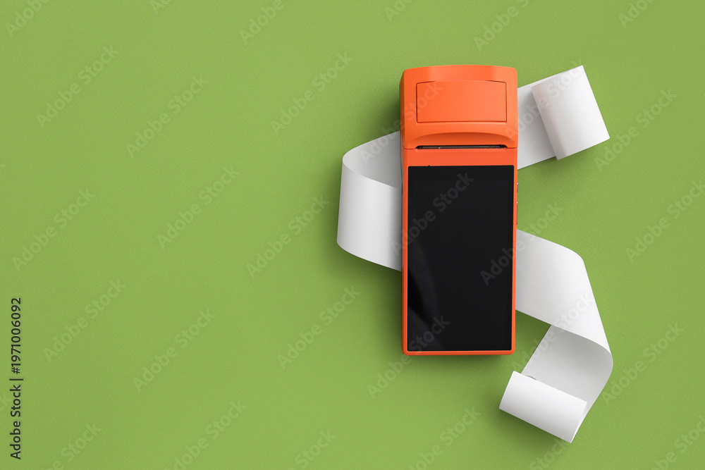 Obraz premium Payment terminal with receipt paper on green background