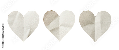 Three folded handmade craft paper heart shapes with crease lines on a transparent background