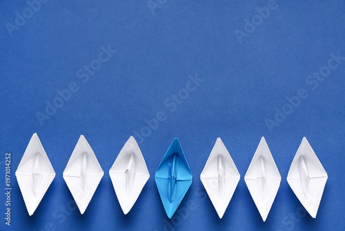 One blue origami boat among...