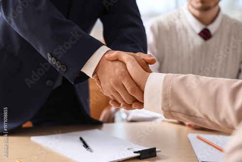 Quadro su tela Female business mediator with clients shaking hands at table in office, closeup