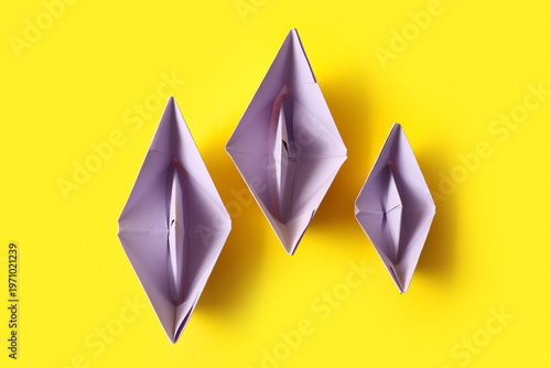 Obraz na płótnie Lilac paper boats on yellow background
