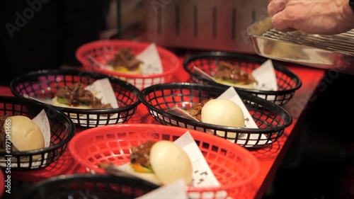 Close-up of a chef’s hands preparing meat bao buns