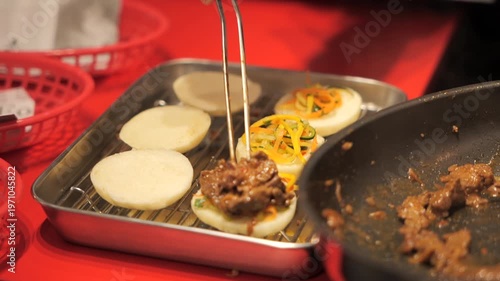 Close-up of a chef’s hands preparing meat bao buns