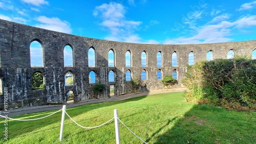 Foto Curved stone arches of McCaig’s Tower rise above the hillside in Oban, Scotland, overlooking the sea