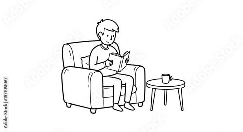 Young man in armchair engrossed in reading a book, with a mug on a small side table next to him