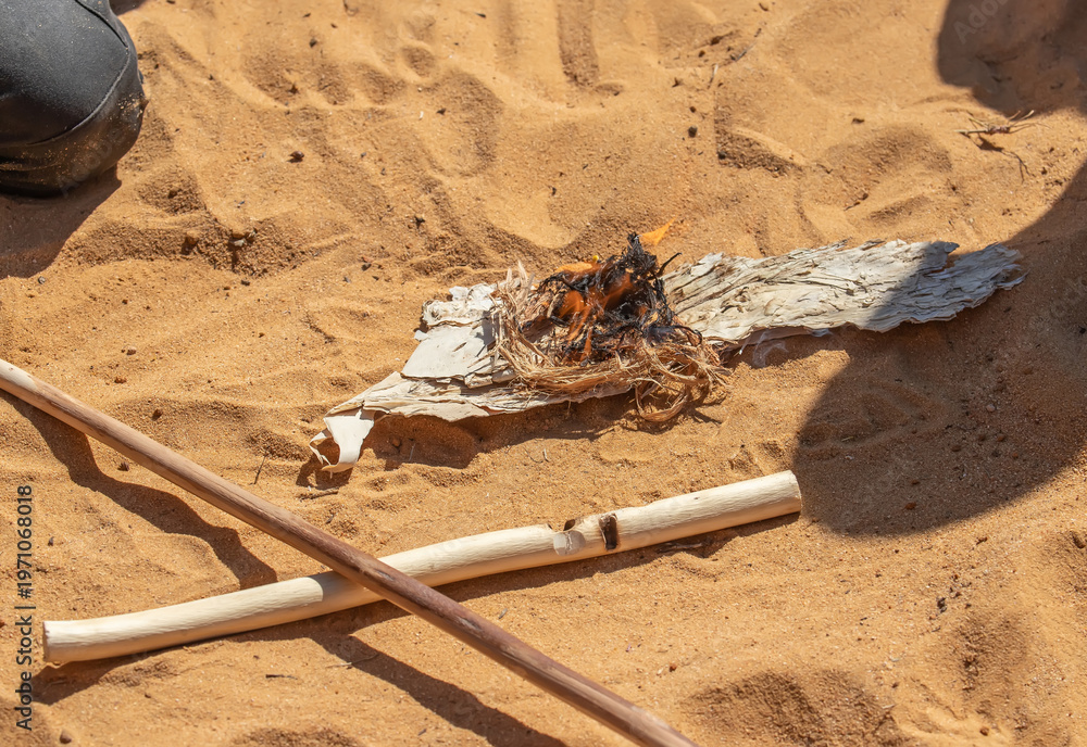 Obraz premium Traditional fire making by friction using wooden sticks in Australian indigenous survival practice