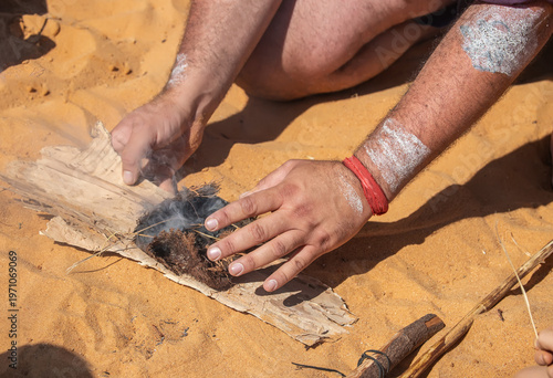Traditional fire making by friction using wooden sticks in Australian indigenous survival practice